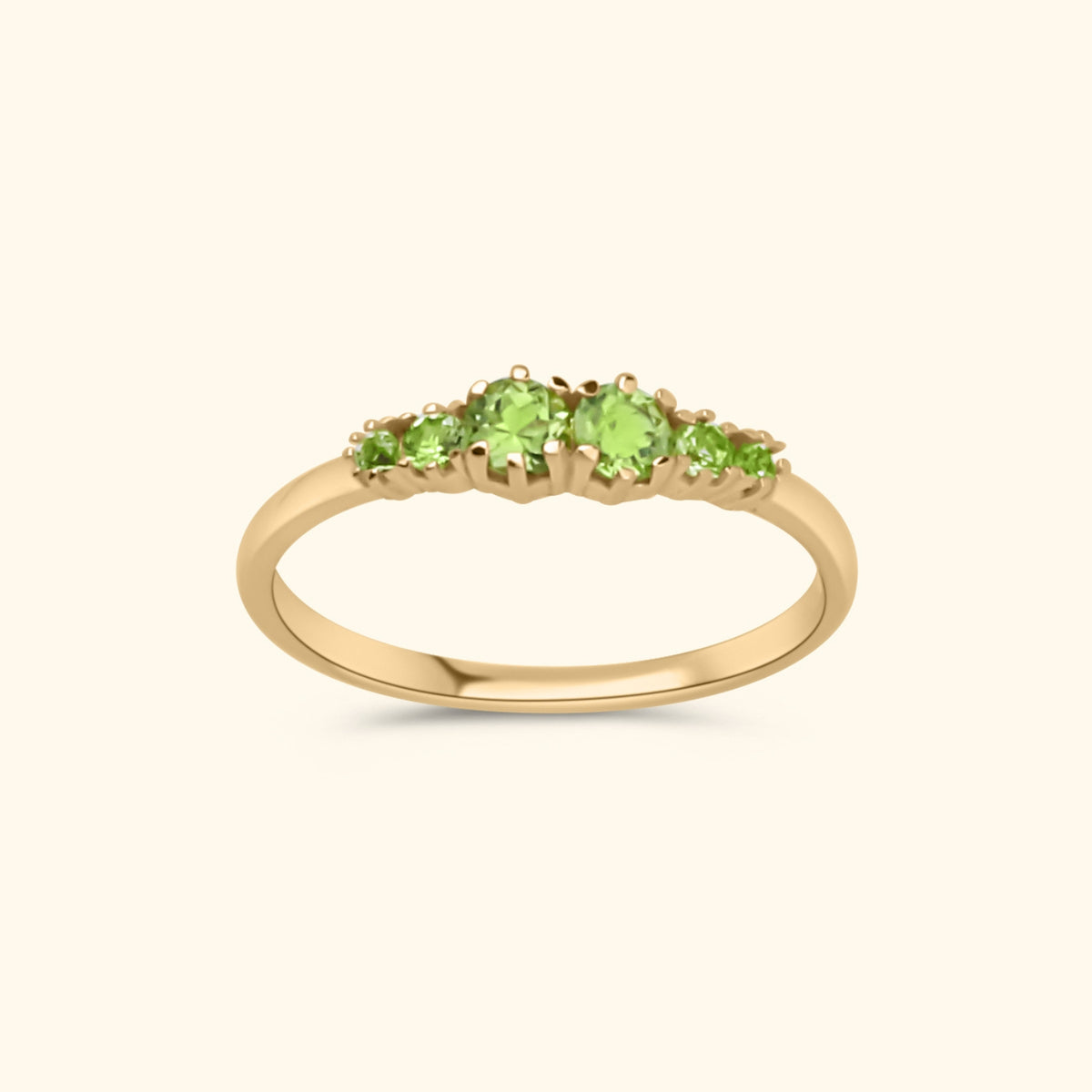 Goudkleurige ring met zes heldergroene peridot stenen in oplopende grootte, gezet in gold plated messing.